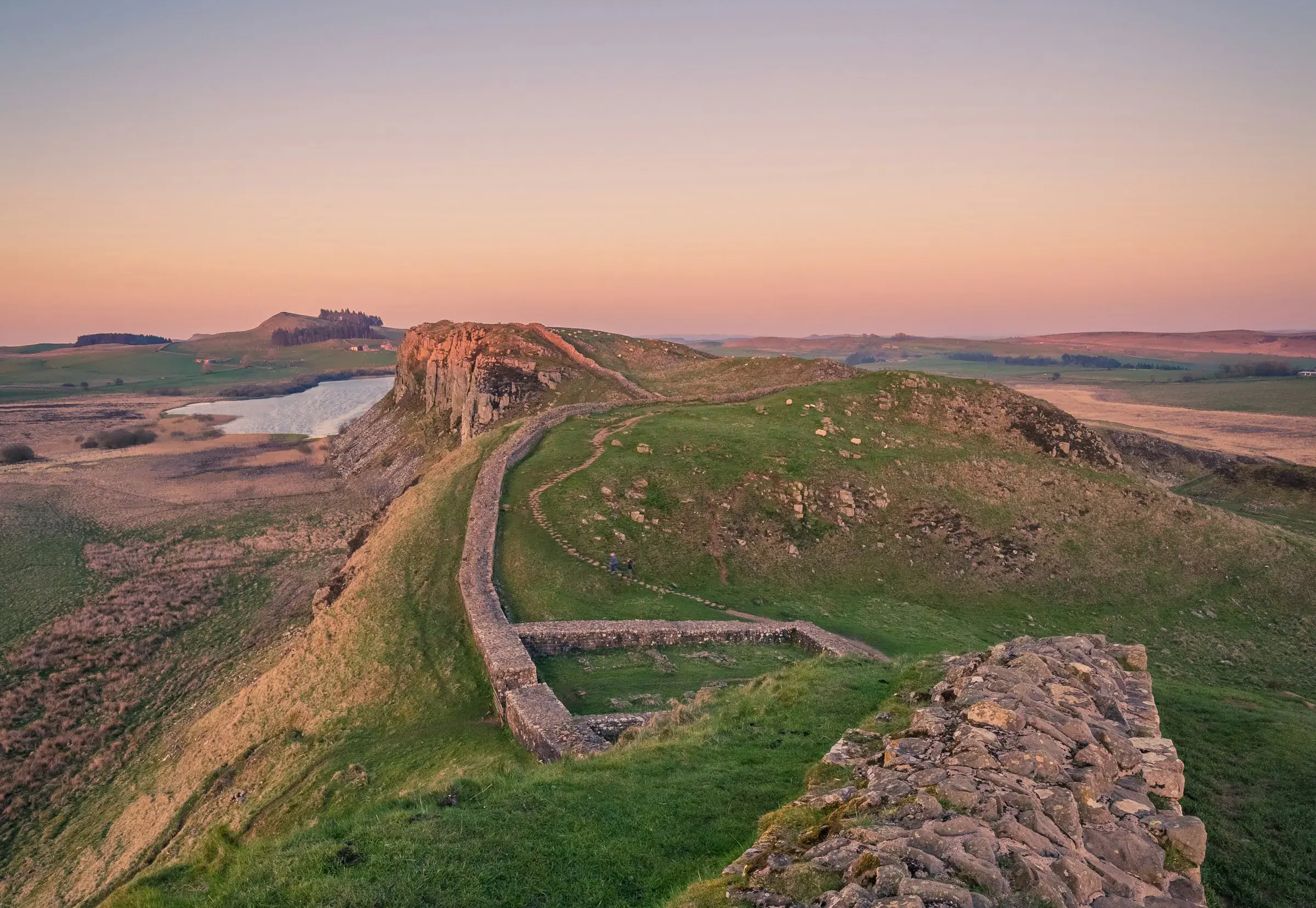 Hadrian's Wall running east along the crags of the Whin Sill at first light